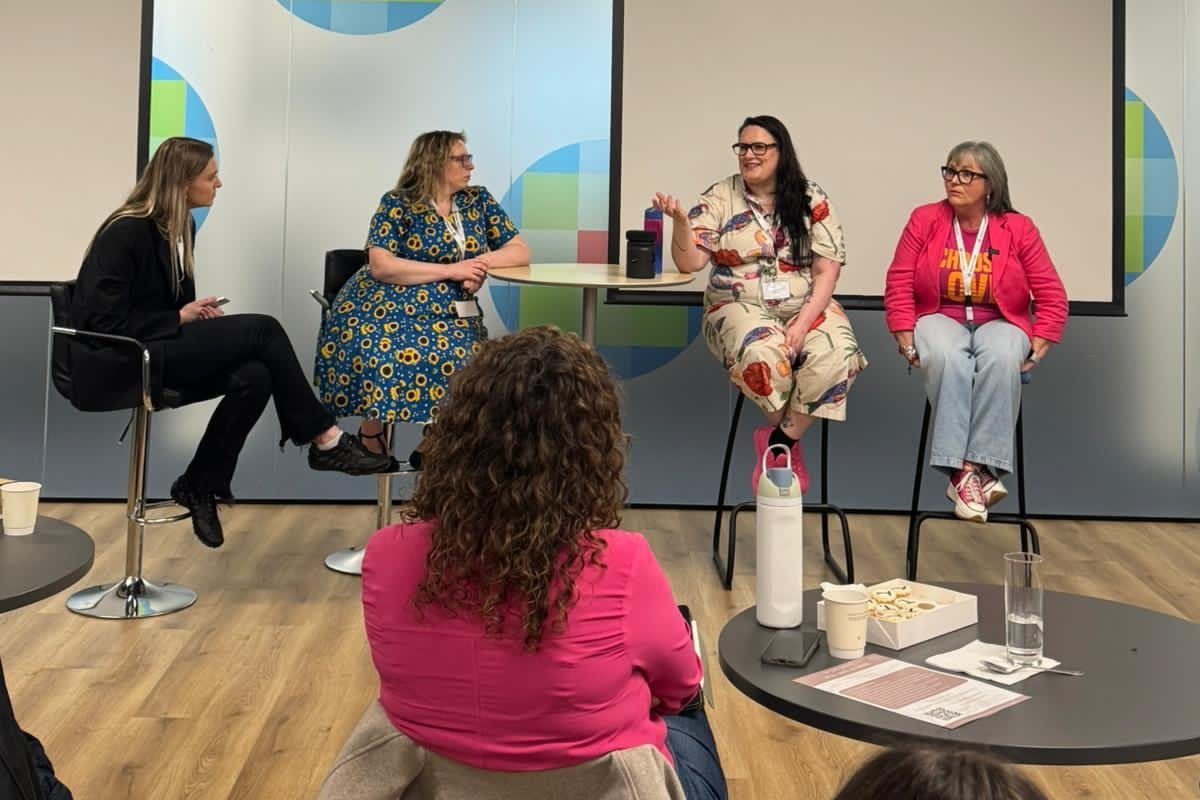 Wendy ‘wo0’ Gannon in a bold printed outfit speaking on a panel of four women